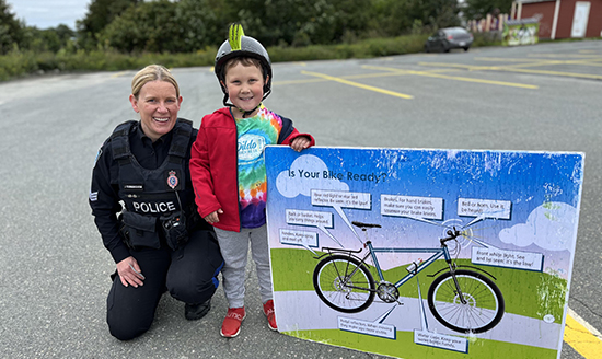 Officer with little boy in bike helmet
